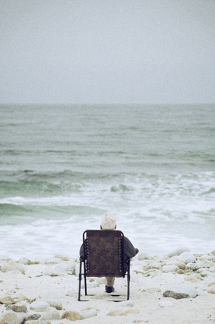 Elderly Person sitting looking at the sea